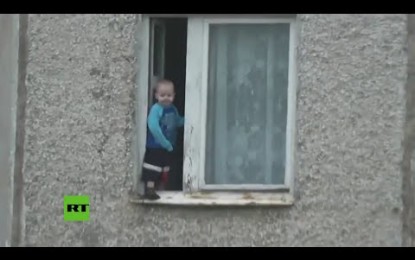 ¿Y los padres?: un niñojuega en la ventana de un piso octavo